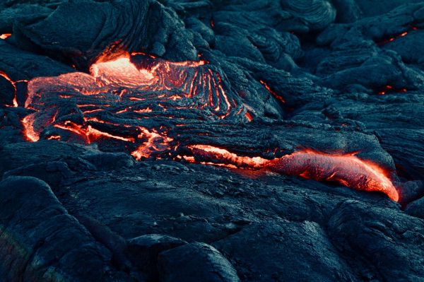 A mesmerizing view of flowing lava on a volcanic landscape, capturing the intense heat and texture.