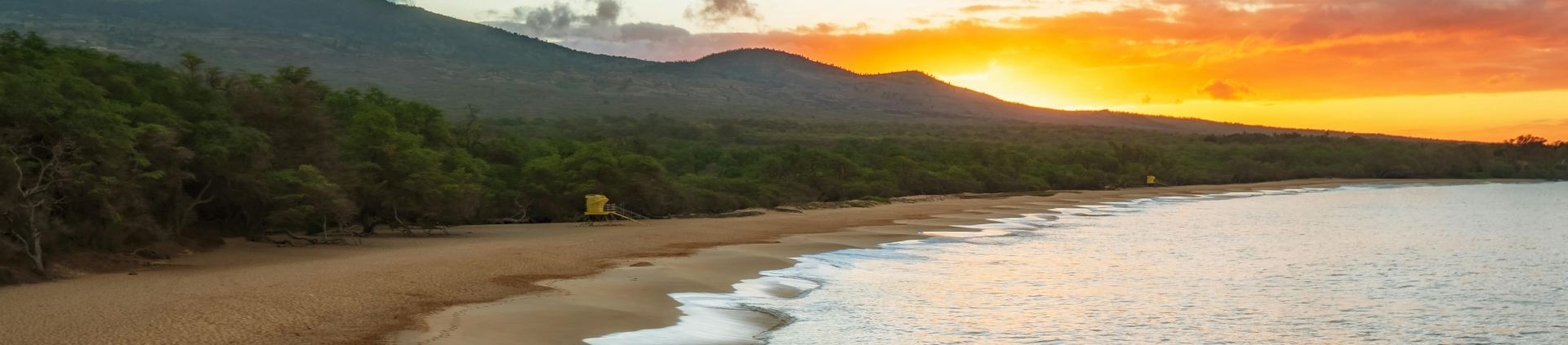 Serene sunset at Makena Beach, Maui, with ocean waves lapping the shore.