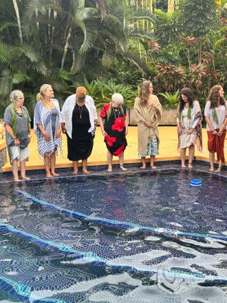 Stunning drone shot of surfers waiting for waves in the clear waters of Hawaii.