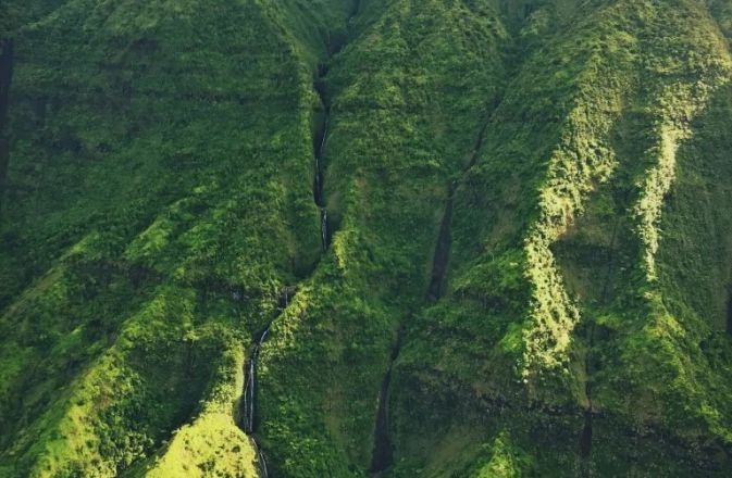 Stunning drone shot of surfers waiting for waves in the clear waters of Hawaii.